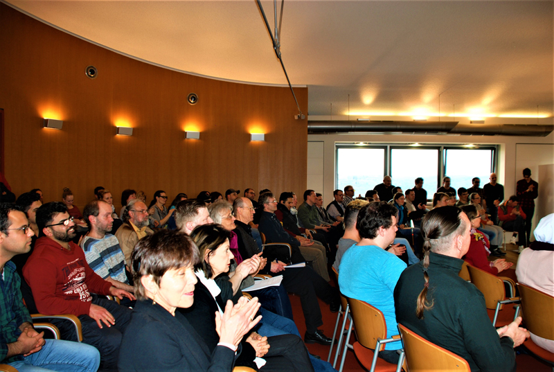 Dichtgedrängt und in vielen Reihen sitzen die Zuhörer im großen Halbrund des Konferenzraums und hören aufmerksam den vortragenden Referenden zu. Dichtgedrängt und in vielen Reihen sitzen die Zuhörer im großen Halbrund des Konferenzraums und hören aufmerksam den vortragenden Referenden zu.