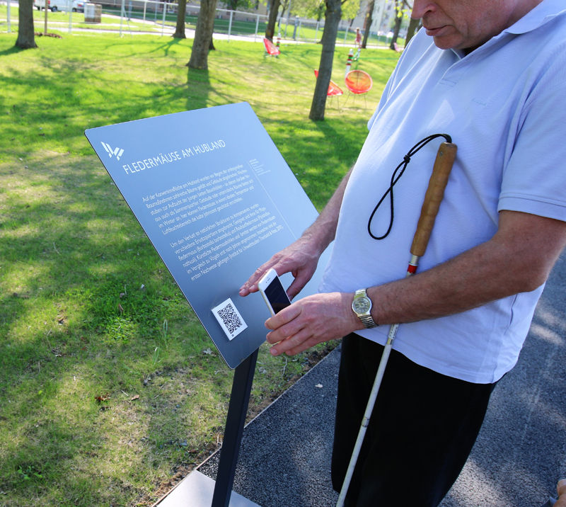 Blinder Besucher der Landesgartenschau hält ein Smartphone und scannt einen QR-Code ein. Blinder Besucher der Landesgartenschau hält ein Smartphone und scannt einen QR-Code ein.