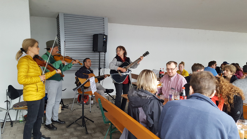 Die Gäste sitzen an langen Biertischen gut geschützt im trockenen Carport und lauschen den vier Musikern der Liveband Castan. Die Gäste sitzen an langen Biertischen gut geschützt im trockenen Carport und lauschen den vier Musikern der Liveband Castan.