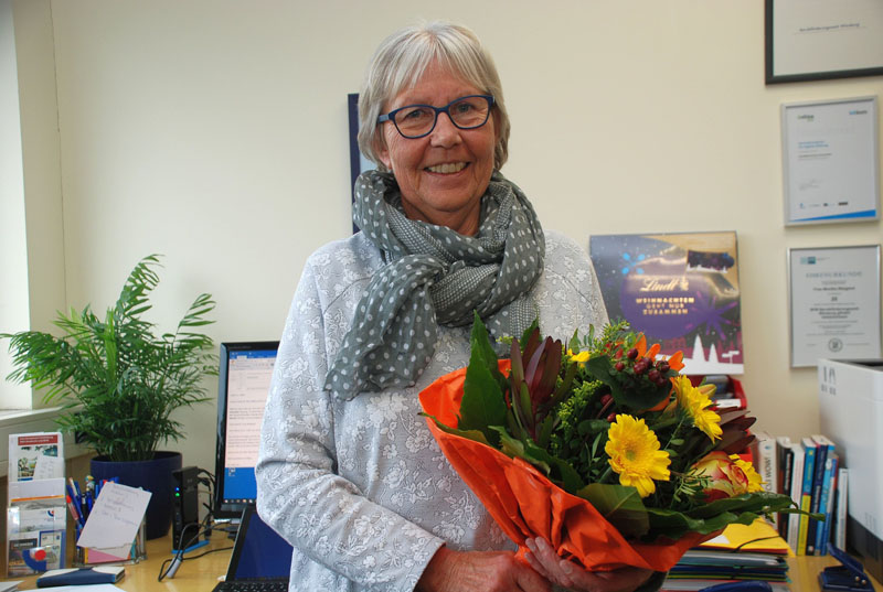 Foto Monika Weigand mit Blumenstrauß in ihrem Büro Foto Monika Weigand mit Blumenstrauß in ihrem Büro